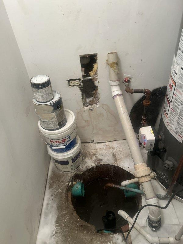 Responded to emergency call for leaking sump pump in utility room. Upon arrival, found existing sump pump of unknown age actively leaking and failing to operate properly, with visible water damage and staining on concrete floor around basin. Assessed system and determined pump had reached end of service life and required immediate replacement to prevent flooding. Removed failed submersible pump from basin, inspected discharge piping and check valve for proper operation, and installed new green submersible sump pump with appropriate horsepower rating for residential application. Verified all PVC discharge connections were secure and tested pump cycling operation to ensure proper activation at correct water levels. System now functioning correctly with no leaks detected.