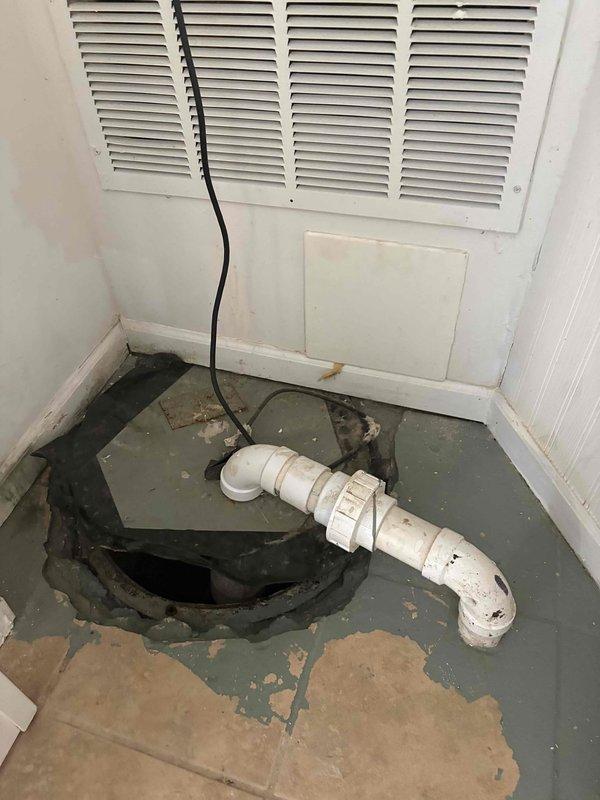 Responded to inspection request for sump pump emitting sewer gas odors in basement. Identified improperly seated lid on front sump pump as primary source of smell, with pump requiring full bucket of water to trigger cycle and temporarily clear odor. Noted tile installation around check valve creating potential access restriction that may require removal for future repairs. Documented second water shutoff valve in same vicinity behind access panel requiring replacement, with limited accessibility due to confined workspace. Photographed sump pit configuration showing PVC discharge piping, electrical connections, and overall condition of mechanical space for service records.
