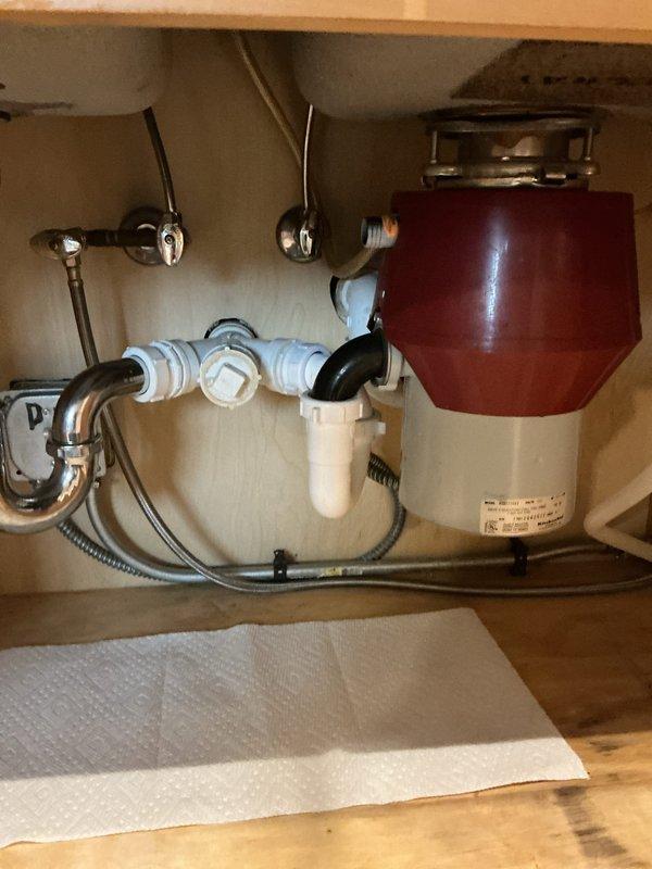 Installed customer-supplied garbage disposal unit under kitchen sink, connecting all drain lines and ensuring proper mounting and seal integrity. Addressed mineral deposit buildup at bathroom plumbing connections that was causing a slow drip, cleaning and treating affected fixtures. Resolved slow-draining kitchen sink issue by verifying proper drainage flow through new disposal unit and P-trap assembly.