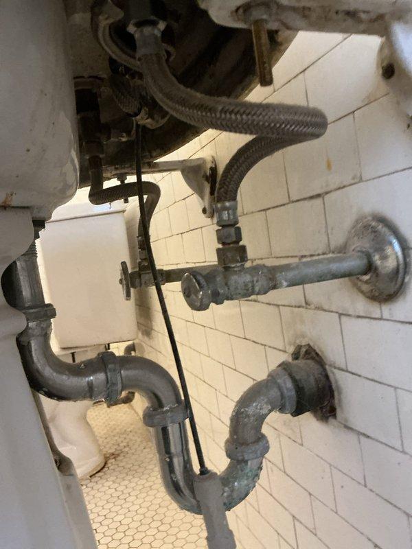 Responded to service call for leaking faucet and faulty shut-off valves beneath bathroom sink. Upon inspection, found aged plumbing fixtures with corroded P-trap assembly and deteriorating shut-off valves that failed to completely stop water flow. Replaced both wall-mounted shut-off valves with new chrome-finished angle stops, installed new flexible braided supply lines, and addressed the leaking faucet connections. All connections were tested for proper operation and verified complete water shut-off capability at the new valves.