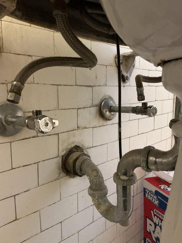 Responded to service call for leaking faucet and faulty shut-off valves beneath bathroom sink. Upon inspection, found aged plumbing fixtures with corroded P-trap assembly and deteriorating shut-off valves that failed to completely stop water flow. Replaced both wall-mounted shut-off valves with new chrome-finished angle stops, installed new flexible braided supply lines, and addressed the leaking faucet connections. All connections were tested for proper operation and verified complete water shut-off capability at the new valves.
