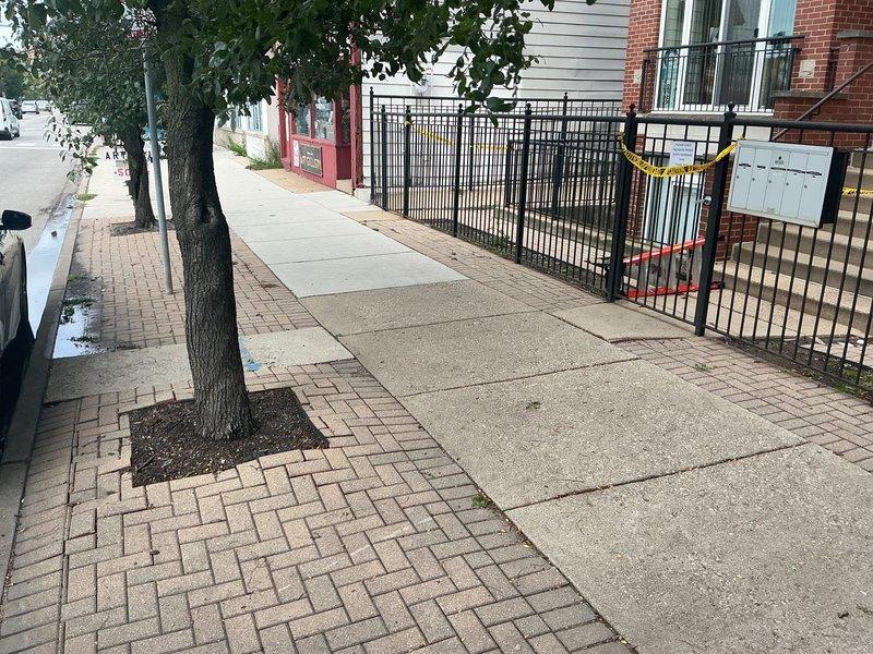Responded to commercial property for sinkhole assessment in front of building. Upon arrival, identified significant subsurface void that had caused sidewalk collapse near street-level entrance. Sinkhole located adjacent to decorative brick paver border and concrete walkway, creating safety hazard for pedestrian traffic. Area secured with caution tape to prevent public access during evaluation.

Conducted visual inspection revealing deteriorated conditions beneath surface pavement, with evidence of soil erosion and settlement around utility corridor. Documented compromised paving stones and structural integrity issues at building perimeter where foundation meets public walkway. Photographed extent of damage including affected sidewalk sections, tree well areas, and proximity to wrought iron fencing and residential structures.

Prepared comprehensive estimate for drain and sewer line investigation, including camera inspection to determine if failed underground infrastructure contributed 