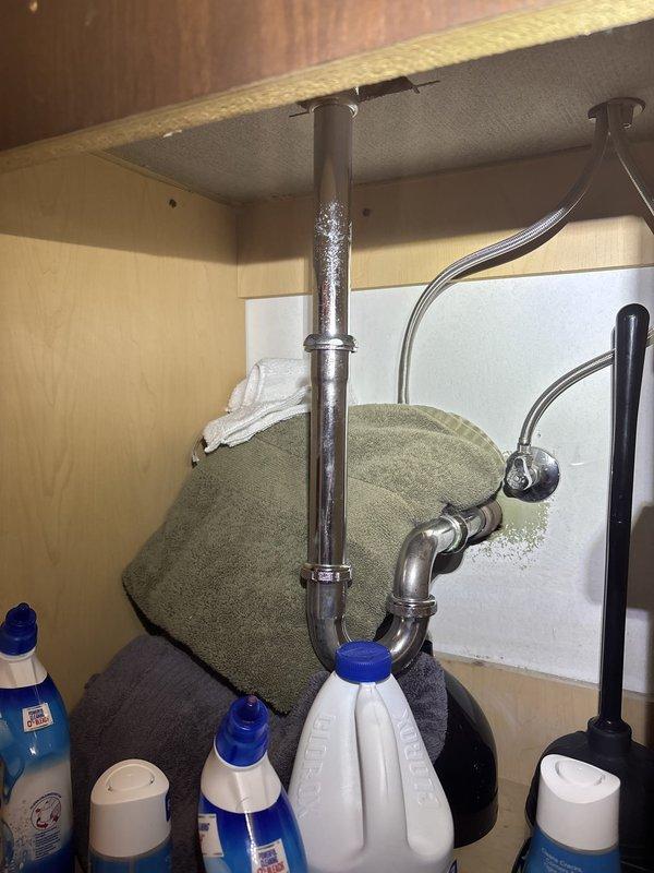 Responded to reported ceiling leak and conducted annual tanked water heater maintenance inspection. Upon arrival, accessed fourth-floor unit via elevator and performed comprehensive visual assessment of plumbing systems. Inspected under-sink plumbing, confirming P-trap and drain connections were secure with no active leaks detected at cabinet fixtures. Examined water heater system and identified severe corrosion on left vertical pipe with heavy rust buildup and deterioration, while adjacent pipe showed moisture condensation with mineral deposit streaking. Documented conditions with photographs for records. Water heater operational but left pipe corrosion presents concern for future integrity. No immediate leaks found at time of inspection; recommended monitoring corroded components for potential replacement to prevent future failure.