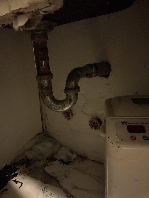 Responded to emergency call for kitchen sink actively leaking due to complete rust-through failure of drain assembly. Upon arrival, found severely corroded P-trap and drain piping with extensive deterioration causing uncontrolled water discharge. Existing drain system showed advanced age with significant rust penetration compromising pipe integrity. Shut off water supply and removed failed rusted drain components including P-trap assembly and connecting tailpiece. Installed new chrome-plated drain assembly with properly sized P-trap, ensuring proper slope and secure wall mounting. Tested system for leaks under full water flow and verified proper drainage function. Cleaned work area and disposed of corroded materials.