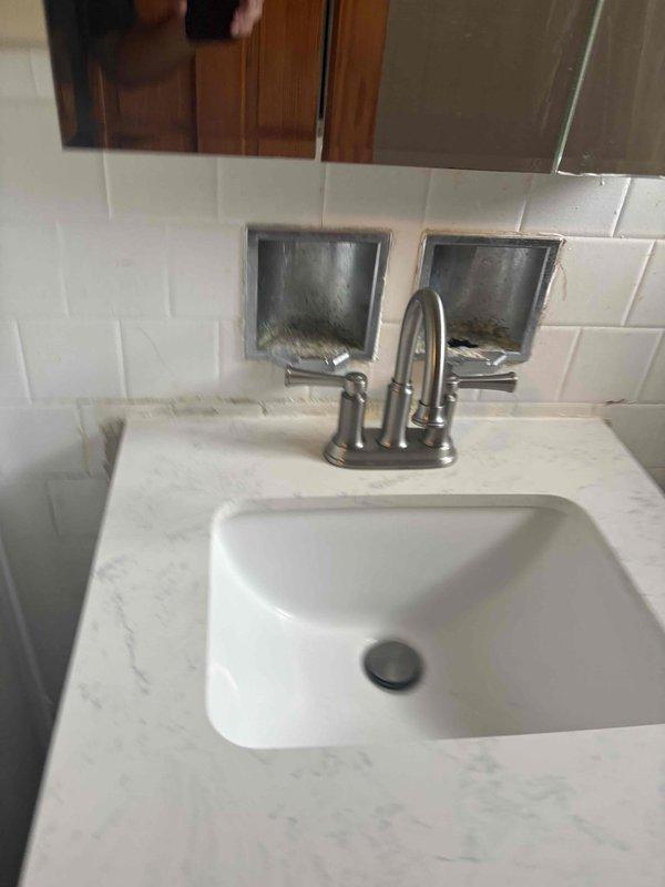 Conducted plumbing estimate for installation of water supply lines to accommodate second-floor laundry facilities where no existing plumbing infrastructure is present, and assessed kitchen dishwasher installation requirements. Documented current bathroom fixtures showing signs of water damage, mineral deposits, and deteriorated finishes to evaluate overall plumbing system condition prior to planned expansion work.
