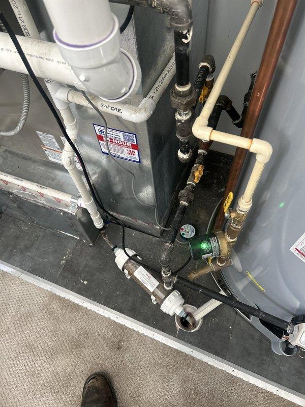 Responded to emergency water leak through ceiling with unknown source. Upon inspection of utility area and plumbing infrastructure, examined water heater, associated piping systems, and HVAC ductwork to identify leak origin. Investigated complex network of PVC, copper, and brass piping connections, valves, and fittings throughout mechanical space. Inspected HVAC air handler system and ductwork with insulation for signs of moisture intrusion or condensate issues. Documented conditions with photographic evidence showing plumbing equipment, pipe configurations, and interior ductwork access points for further diagnostic evaluation and repair planning.