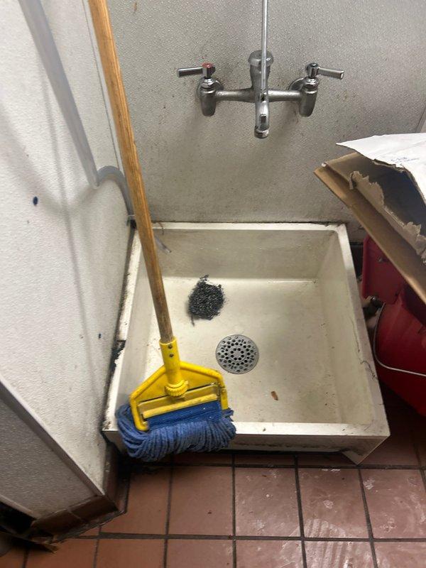Responded to emergency service call where fire department and People's Gas had shut down water heater due to exhaust venting issues. Upon arrival, inspected water heater installation and identified improper venting causing potential carbon monoxide hazard. Documented existing conditions including water heater unit, venting system, gas connections, and utility sink area. Observed water damage on floor tiles surrounding base of equipment indicating possible additional concerns. Photographed all relevant components and safety equipment including mounted fire extinguisher. Provided comprehensive estimate for necessary repairs to address exhaust venting problem and restore water heater to safe operating condition per code requirements.