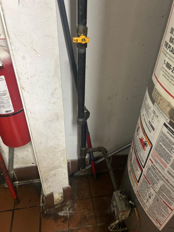 Responded to emergency service call where fire department and People's Gas had shut down water heater due to exhaust venting issues. Upon arrival, inspected water heater installation and identified improper venting causing potential carbon monoxide hazard. Documented existing conditions including water heater unit, venting system, gas connections, and utility sink area. Observed water damage on floor tiles surrounding base of equipment indicating possible additional concerns. Photographed all relevant components and safety equipment including mounted fire extinguisher. Provided comprehensive estimate for necessary repairs to address exhaust venting problem and restore water heater to safe operating condition per code requirements.