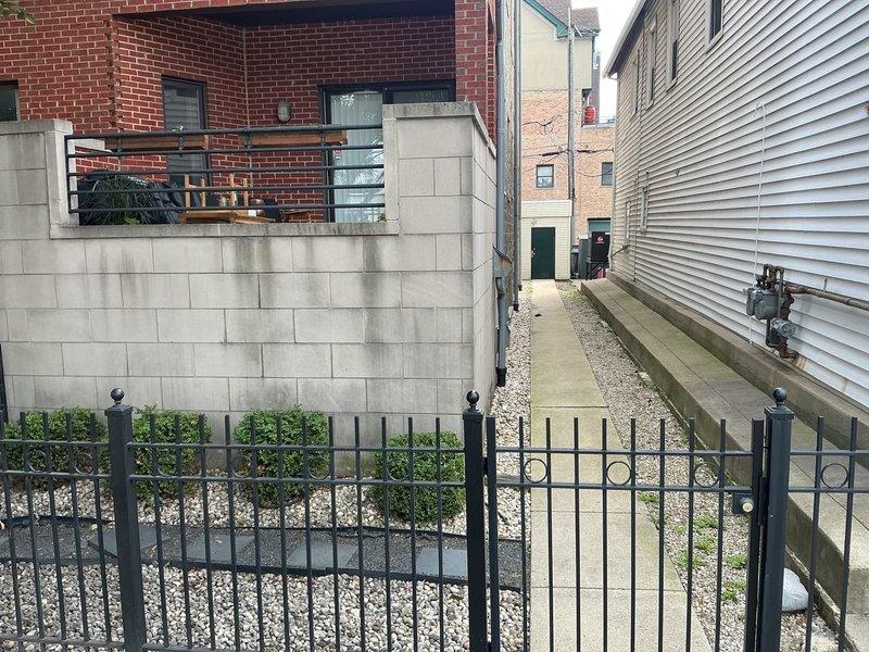 Responded to service call for reported broken sewer pipe at commercial property. Conducted thorough site inspection of exterior premises, including alleyway access between buildings and lower-level entry points. Documented conditions via photography showing gravel alley pathway bordered by brick and vinyl-sided structures, exterior foundation walls, and basement-level access areas with landscaping features. Assessment included examination of accessible sewer line routing, building perimeter drainage components, and potential excavation points for pipe repair or replacement.