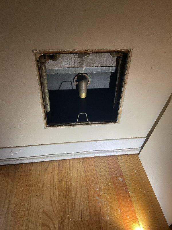 Inspected plumbing system and wall-mounted utility access point. Documented existing conditions including aged mechanical infrastructure with deteriorated pipe insulation, pressure relief valve assembly, and multiple water supply lines. Return visit scheduled to complete additional work per customer request.