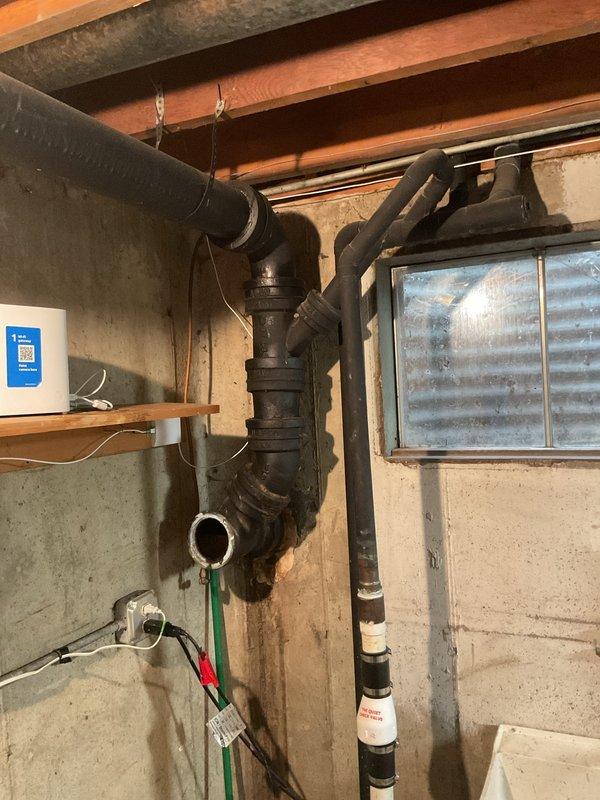 Responded to a reported broken sewer line at a residential property for inspection and assessment. Upon arrival, conducted a thorough examination of the existing cast iron plumbing system in the basement utility area and exterior sewer access points along the side of the building. Inspected the main sewer line configuration, pipe connections, and drainage system components to identify the source and extent of the failure. Documented conditions of the plumbing infrastructure including the cast iron waste stack, pipe joints, and exterior access areas where markers indicated potential excavation or repair zones. Provided the homeowner with findings from the inspection and recommendations for necessary repairs to restore proper sewer line function.