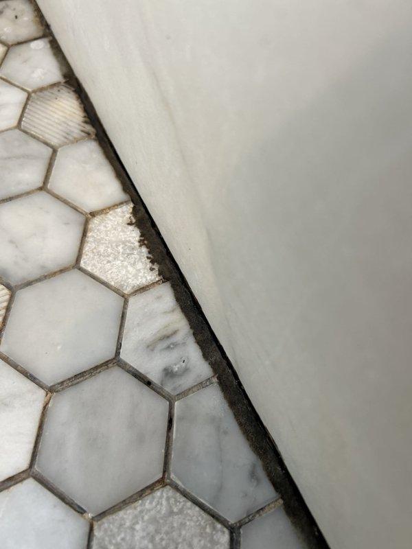 Responded to service call for multiple water leaks, including chronic ceiling leak originating from upstairs bathroom. Performed visual inspection and documentation of three reported leak locations. Identified active water damage on ceiling with visible cracking, peeling material, and structural deterioration above cabinetry. Inspected upstairs bathroom floor area where hexagonal tile meets bathtub/shower base, noting deteriorated grout lines, tile discoloration, and erosion at fixture junction indicating potential water intrusion point. Documented all affected areas with photographic evidence for further evaluation and repair recommendations.