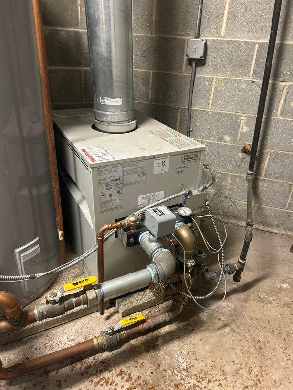Responded to a service call for residential plumbing system evaluation. Upon inspection of the basement mechanical room, assessed the existing heating system, water heater, and associated plumbing infrastructure. The system includes a wall-mounted heating unit with ductwork, a standard residential water heater, and a red expansion tank with supporting plumbing connections.

Examined the condition of copper and galvanized piping throughout the system, noting age-related patina and oxidation on various components. Inspected all visible valves, gauges, pressure relief mechanisms, and brass fittings for proper operation and potential concerns. Documented the current state of the mechanical equipment including pipe connections, flexible hoses, and safety devices attached to both the heating unit and water heater.

Provided professional assessment and recommendations to the customer regarding the plumbing system's condition. Customer approved proposed repair work, and sale was successfully c