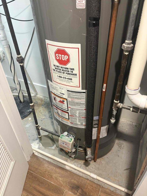 Picked up flame verification sensor from Addison Street location for HVAC unit servicing. Documented existing water heater installation and associated plumbing connections, including copper and PVC piping configurations with flow meter. Replacement of flame verification sensor scheduled for following day to restore proper furnace operation and safety controls.