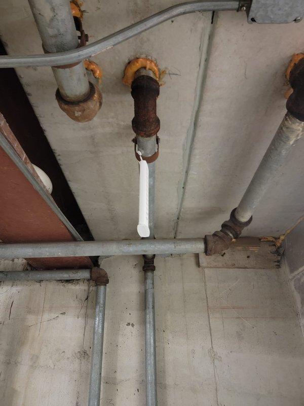 Responded to a blocked condensate drain call and performed inspection of the plumbing system. Upon arrival, located the condensate drain line in the basement utility area and identified blockage preventing proper drainage. Cleared the obstruction from the condensate line using appropriate tools and verified proper flow was restored. Inspected surrounding plumbing infrastructure during service, noting significant rust and corrosion present on older metal piping components including vertical drain pipes and trap assemblies, though these were not affecting current system operation. Condensate drain is now flowing freely and functioning as designed.