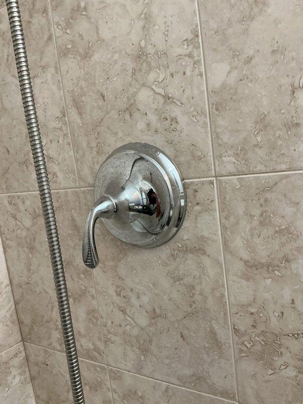 Responded to service call for leaking bathtub faucet in residential bathroom with alcove-style tub/shower combination. Upon inspection, documented existing chrome tub spout and shower valve system with handheld and fixed showerhead configuration installed on beige marble-pattern tiled surround. Photographed current fixture conditions and plumbing layout for assessment and estimate preparation, with follow-up appointment scheduled to complete necessary repairs.