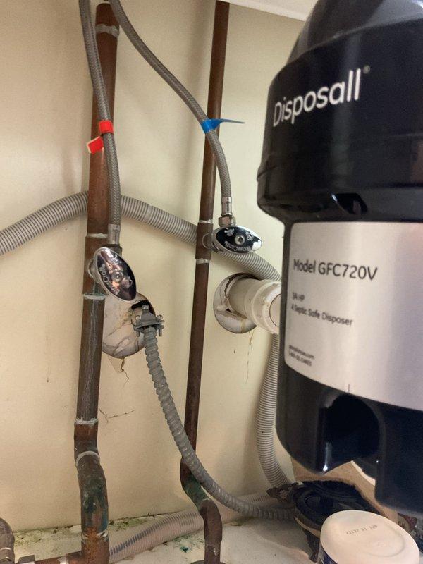 Installed customer-supplied chrome pull-down kitchen faucet with commercial-style coiled spring design at white farmhouse sink. Connected water supply lines to existing copper plumbing infrastructure and verified proper operation of spray function and handle controls, ensuring no leaks at all connection points.