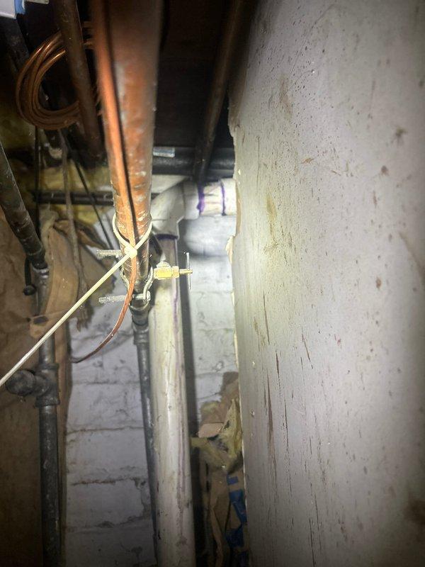 Completed under-sink plumbing repair involving replacement and reconfiguration of PVC drain assembly including P-trap and associated fittings beneath kitchen sink. Additionally performed copper pipe repairs and modifications in basement utility area, addressing water supply lines and ensuring proper connections and support throughout the plumbing system.