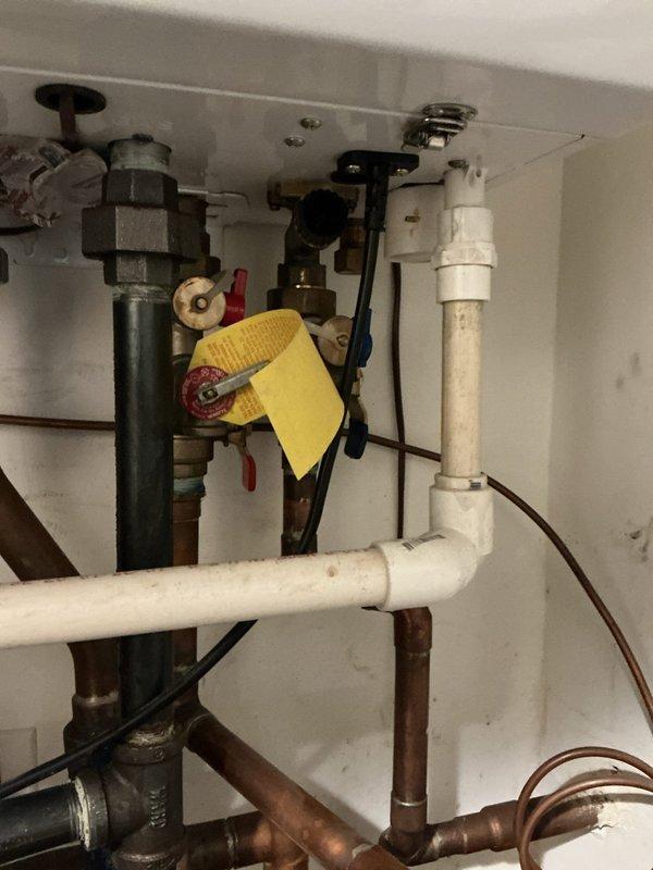 Responded to complaint of black and grayish sediment accumulating in toilet bowl after flushing. Conducted thorough inspection of toilet fixture and associated plumbing connections to determine source of discoloration. Examined under-sink plumbing infrastructure, including supply lines, shut-off valves, and pipe connections for potential sediment sources or corrosion. Inspected HVAC condensate drain pan which showed significant mineral deposits and rust staining, indicating potential water quality issues affecting multiple fixtures. Determined sediment issue was related to water quality rather than toilet malfunction, with mineral deposits and corrosion present throughout plumbing system. Documented conditions with photographs for record.
