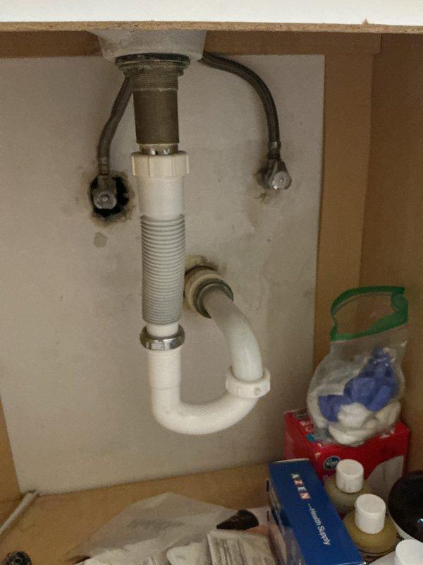 Completed estimate for installation of three kitchen plumbing fixtures: kitchen faucet, under-sink water filtration system, and garbage disposal unit. Inspected existing under-sink plumbing configuration, including current drain assembly with P-trap, flexible water supply lines, and cabinet space availability. Documented existing plumbing conditions via photographs showing standard drain tailpiece, corrugated flexible drain pipe, and current disposal unit with mounting assembly. Assessed cabinet interior dimensions and plumbing layout to determine installation requirements for requested fixtures. Provided comprehensive estimate for fixture replacement and installation services.