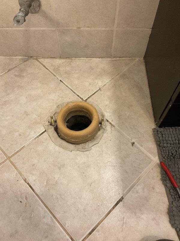 Responded to report of blue-tinted water spots appearing on basement ceiling directly below main floor bathroom toilet. Upon arrival, conducted thorough inspection of toilet installation, wax ring seal, supply line connections, and tank components. No visible active leaking observed in bathroom during inspection. Customer confirmed use of blue toilet cleaning pods which traced leak source through water discoloration on ceiling below. Inspected floor flange area and identified compromised wax ring seal allowing water to seep through floor penetration during flush cycles. Removed toilet, scraped old wax ring, inspected flange for damage and proper alignment, and installed new wax ring seal. Reinstalled toilet with proper compression, torqued closet bolts to specification, and reconnected water supply line. Performed multiple flush tests to verify proper seal and confirm no water migration through floor. Advised monitoring basement ceiling area for any additional moisture concerns.