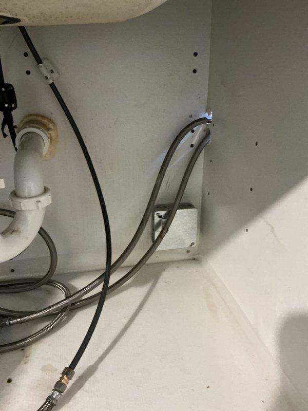 Completed installation of reverse osmosis water treatment system and garbage disposal unit under kitchen sink. Installed RO system with appropriate supply line connections, drain saddle, and storage tank in cabinet space. Connected new garbage disposal with electrical wiring and discharge plumbing to existing drain system, ensuring proper alignment and secure mounting to sink flange.
