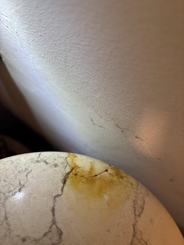 Responded to water intrusion complaint originating from upper unit bathroom leaking into lower unit closet area containing water heater. Performed leak detection assessment using electronic moisture detection equipment to identify source and extent of water damage. Documented conditions with photographic evidence showing affected plumbing infrastructure and water-stained surfaces on overhead piping and insulation materials, indicating active leak from upper level plumbing system requiring further investigation and repair coordination between units.
