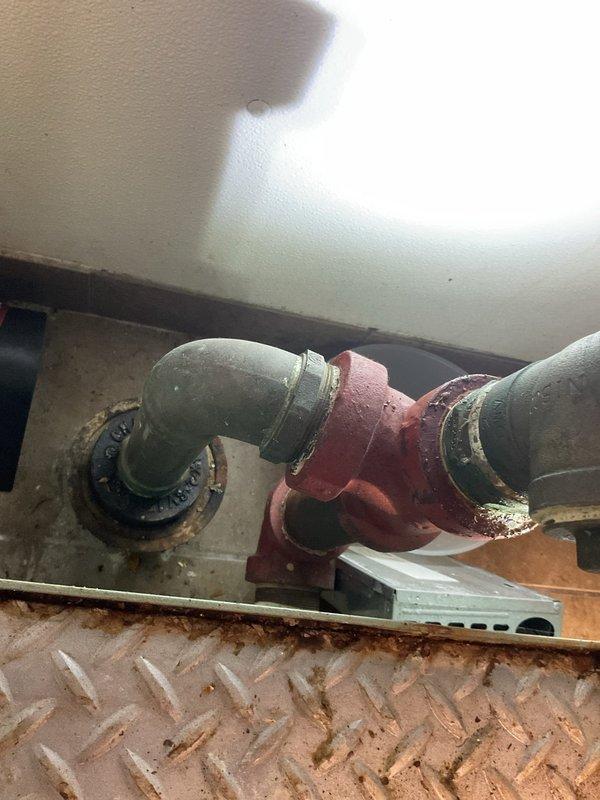 Responded to commercial kitchen for grease trap evaluation. Upon inspection, found existing 20-year-old grease trap showing significant deterioration with visible rust, corrosion around connection points, and active leak at valve body. Unit located beneath triple-basin stainless steel sink with diamond plate flooring access. Documented current condition of red metal valve assembly, inlet/outlet piping, and surrounding plumbing infrastructure. Provided assessment and recommendations for complete grease trap replacement due to age-related failure and compromised structural integrity of existing unit.