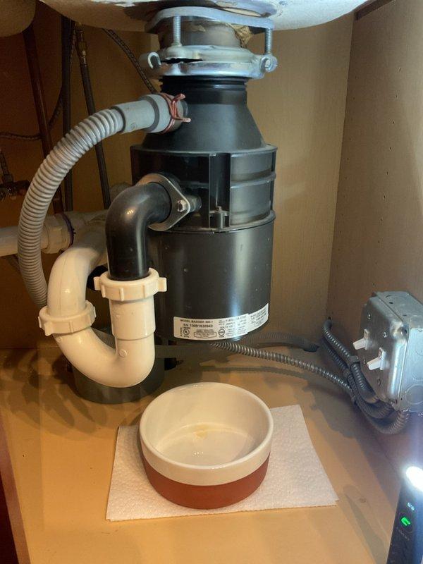 Responded to service call for non-operational garbage disposal unit at kitchen sink. Upon inspection, found the disposal unit had lost power due to a tripped reset button on the bottom of the unit. Verified electrical connection at wall outlet was secure and functioning properly. Pressed the red reset button on the disposal base to restore power. Tested unit operation with cold water running to confirm proper function and verify no unusual sounds, vibrations, or leaks. Inspected mounting assembly, drain connections, and dishwasher drain line for any signs of damage or deterioration—all components found to be in good condition. Checked P-trap configuration and verified proper drainage. Unit restored to full working order.