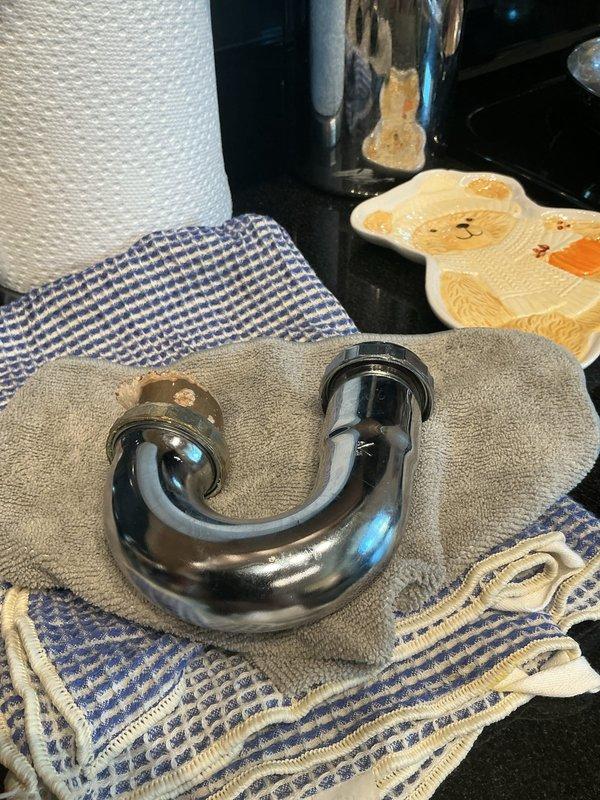 Responded to emergency same-day service request for leaking sink piping. Upon inspection, discovered severely corroded drain trap assembly that had deteriorated and separated during customer's initial investigation. Removed failed chrome-plated P-trap assembly and replaced with new drain piping components, ensuring proper seal and connection integrity. Verified system for leaks and restored full drainage functionality to kitchen sink.