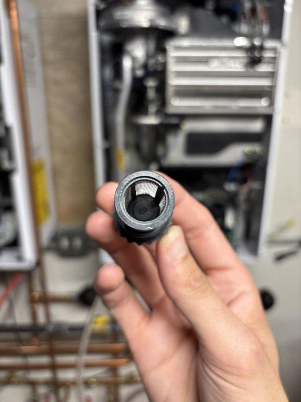 Performed scheduled maintenance on tankless water heater including draining and cleaning the inlet filter screen, which showed typical sediment accumulation. Verified all connections, tested system operation, and confirmed unit was functioning properly with no leaks or performance issues. Additionally inspected washing machine and dryer area in response to odor complaint; assessed drainage connections and ventilation systems for potential sources of the reported smell.