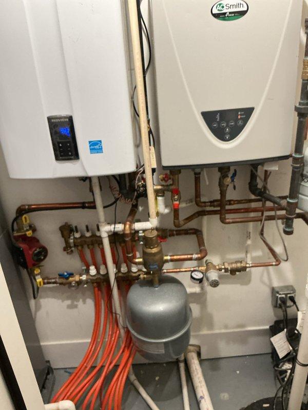 Responded to a follow-up service call for a booster pump system in a 2-unit building that was continuously cycling on and off. Conducted comprehensive evaluation of the booster pump system, including pressure testing, control settings verification, and system diagnostics to isolate the root cause of the cycling issue. Inspected the existing plumbing infrastructure, including tankless water heater connections, expansion tank, pressure regulation components, and associated copper piping and valve assemblies. Examined exterior booster pump components and control mechanisms for proper operation and potential defects. Documented system configuration with photos showing dual tankless water heater setup with integrated plumbing network and external pump controls for further analysis and recommendations.