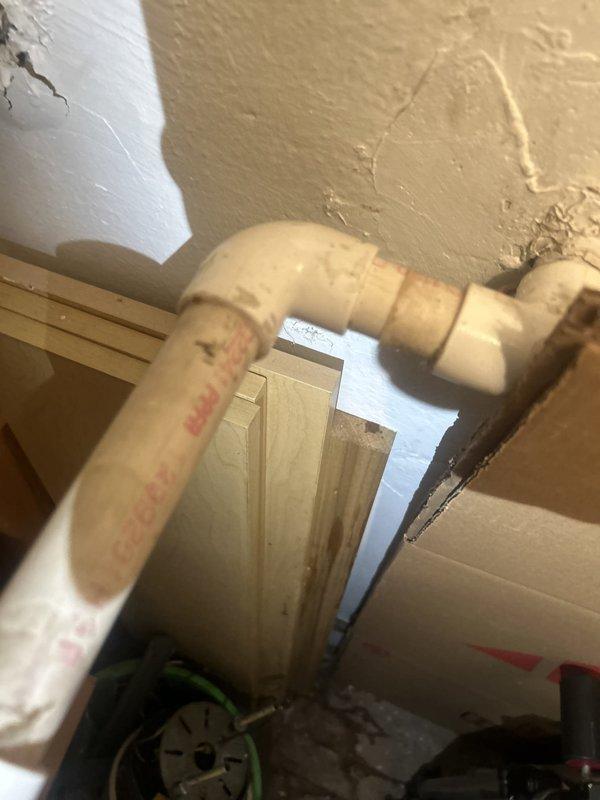 Responded to emergency water leak investigation affecting downstairs unit with ceiling water intrusion originating from upper unit plumbing system. Performed thorough inspection of exposed plumbing infrastructure, identifying aged plastic piping with visible deterioration, discoloration, and potential failure points at elbow joint connections. Documented compromised piping conditions and concrete floor staining consistent with active or recent water leakage in utility area.