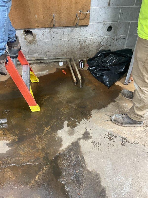 Responded to a drain backup emergency where sewage was backing up through the floor drain and flooding the basement utility room. Upon arrival, found significant standing water with sewage covering the concrete floor throughout the space. Extracted standing water from the affected area and assessed the drainage system to identify the source of the blockage causing the backup through the floor drain. Cleared the obstruction in the main drain line to restore proper flow and prevent further sewage backup into the basement.