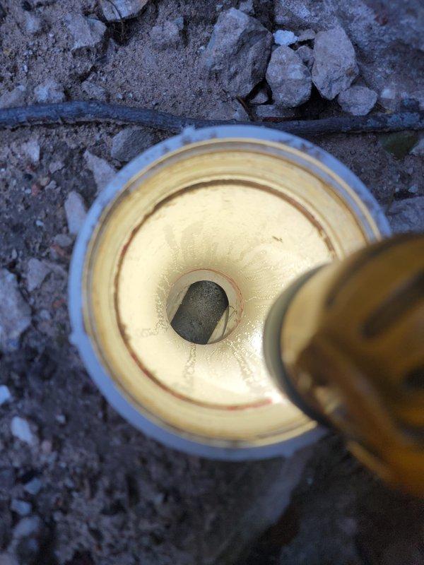 Responded to plumbing service call and completed repair work at residential property. Addressed underground pipe access point issue where copper piping connects to PVC conduit system embedded in concrete surface, and performed bathroom fixture maintenance including toilet paper holder and related bathroom accessories. Documentation photos captured for service records.