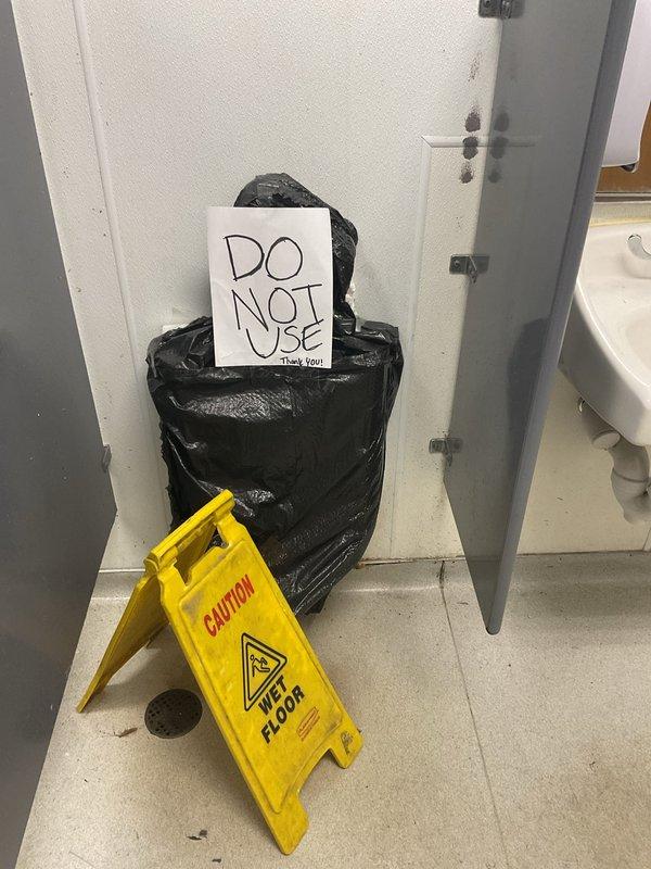 Responded to emergency dispatch for men's restroom urinal overflowing when flushed. Inspected Kohler wall-mounted urinal and flush valve assembly, identified malfunction in flush valve mechanism causing continuous water flow. Repaired flush valve hardware, tested operation to confirm proper flushing cycle without overflow, and placed facility back in service with caution signage removed.