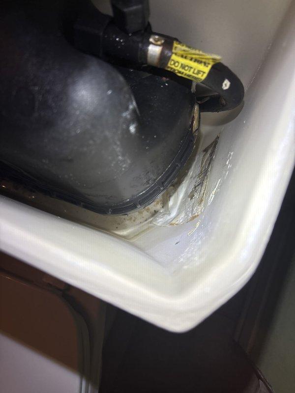 Inspected and assessed water heater system experiencing significant corrosion on metal piping and connections. Documented heavily deteriorated tubing assembly at top of pressure vessel showing extensive rust and oxidation damage. Evaluated condensate pump assembly and drain pan condition, noting moisture accumulation and sediment buildup in collection system. Provided photographic documentation of corroded components and recommended replacement of affected piping to prevent potential system failure and water damage.