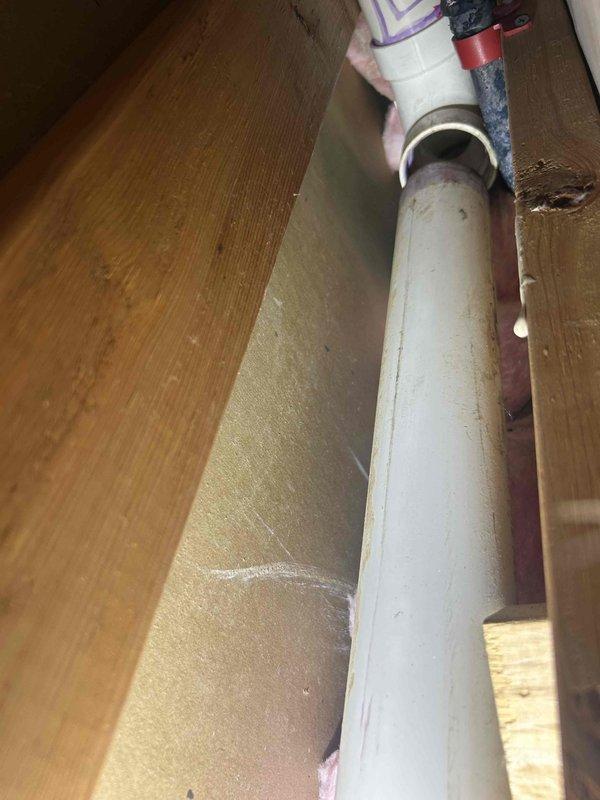 Performed smoke test in attic space to identify source of odor emanating from opened wall cavity. Inspected PVC drain and vent piping throughout accessible areas, including connections, couplings, and fittings between floor joists. No leaks or compromised pipe integrity detected during smoke test; all vent stack connections and drain lines tested satisfactorily with no smoke escaping from joints or pipe body.
