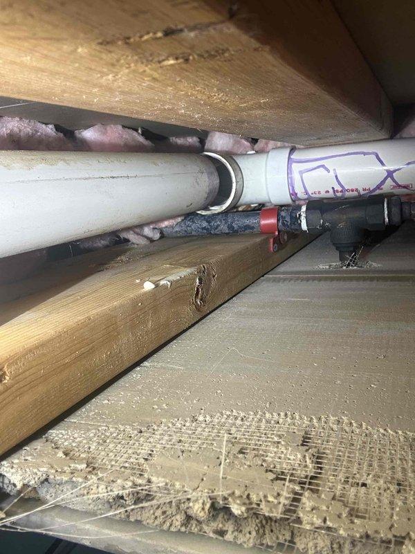Performed smoke test in attic space to identify source of odor emanating from opened wall cavity. Inspected PVC drain and vent piping throughout accessible areas, including connections, couplings, and fittings between floor joists. No leaks or compromised pipe integrity detected during smoke test; all vent stack connections and drain lines tested satisfactorily with no smoke escaping from joints or pipe body.