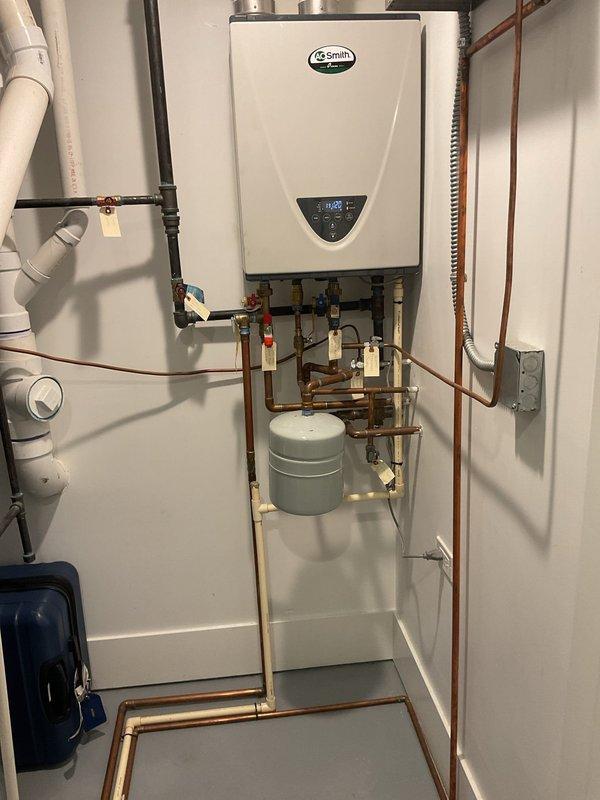 Replaced existing water heating system with new A.O. Smith tankless water heater unit. Installation included complete copper piping network with isolation valves, expansion tank integration, PVC venting system routed through ceiling, electrical connections with dedicated junction box, and pressure relief components. All connections were tested and system commissioned to manufacturer specifications.