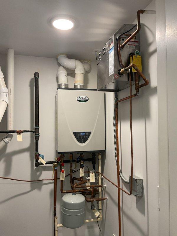 Replaced existing water heating system with new A.O. Smith tankless water heater unit. Installation included complete copper piping network with isolation valves, expansion tank integration, PVC venting system routed through ceiling, electrical connections with dedicated junction box, and pressure relief components. All connections were tested and system commissioned to manufacturer specifications.