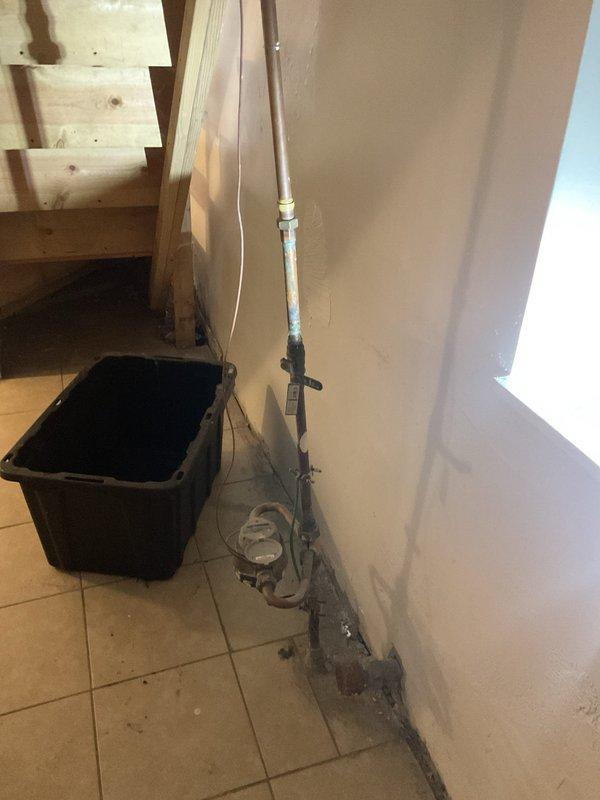Responded to early morning service request to open water main valve for municipal inspection. Upon arrival, accessed basement utility area where main water supply line enters structure. Located and operated main shut-off valve to restore water flow to property, enabling scheduled inspection to proceed. Documented existing plumbing installation including vertical PVC drainage system along interior wall and current condition of utility space for service records.
