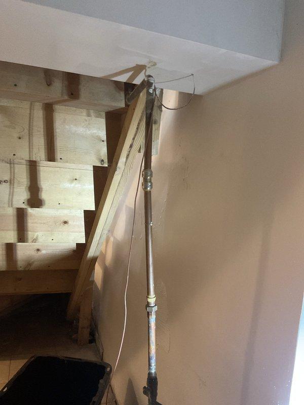 Responded to early morning service request to open water main valve for municipal inspection. Upon arrival, accessed basement utility area where main water supply line enters structure. Located and operated main shut-off valve to restore water flow to property, enabling scheduled inspection to proceed. Documented existing plumbing installation including vertical PVC drainage system along interior wall and current condition of utility space for service records.