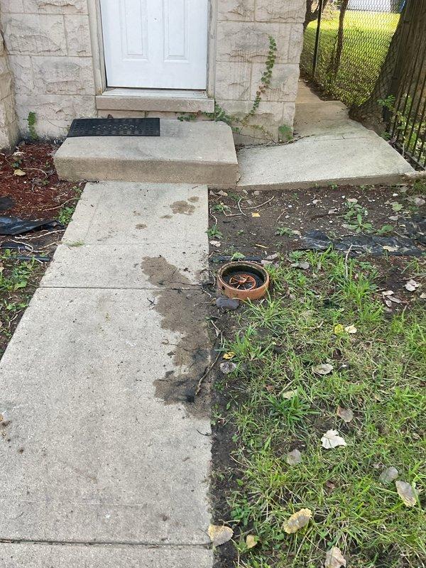 Responded to a residential sewer backup complaint with main line not draining properly. Upon arrival, located and accessed the exterior sewer cleanout near the foundation of the property. Inspection revealed a blockage in the main sewer line preventing proper drainage from the manhole connection. Documented the cleanout access point condition and surrounding area, noting the removal of the cleanout cover to assess the system. Provided estimate for necessary sewer line cleaning and blockage removal to restore proper drainage function.