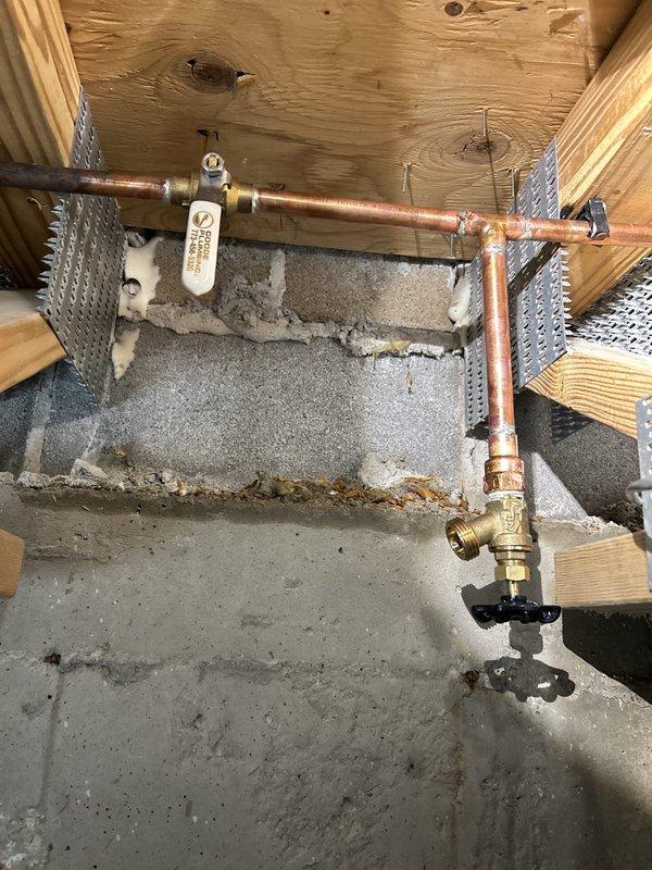 Replaced leaking backyard hose faucet that required interior shutoff to control water flow. Accessed crawl space to install new copper piping with brass fittings and valve assembly, properly secured to floor joists with metal straps. Completed exterior installation with new frost-proof sillcock mounted to exterior wall, restoring full functionality to outdoor water supply without need for manual shutoff.