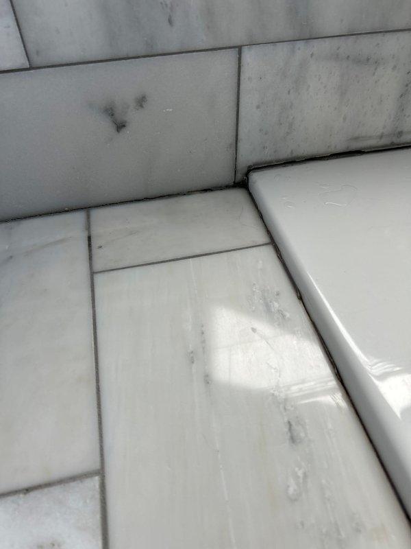 Responded to water intrusion complaint affecting dining room ceiling below master bathroom. Conducted visual inspection of master bathtub area and identified water staining on ceiling panels and surrounding tile surfaces. Recommended opening ceiling to access and identify leak source, followed by diagnostic testing of bathtub drain assembly and faucet connections to determine point of failure. Documented conditions with photographs showing discoloration patterns on ceiling panels and tile surfaces adjacent to tub fixture. Advised client that additional repair recommendations and estimates would be provided upon completion of diagnostic work and leak source identification.