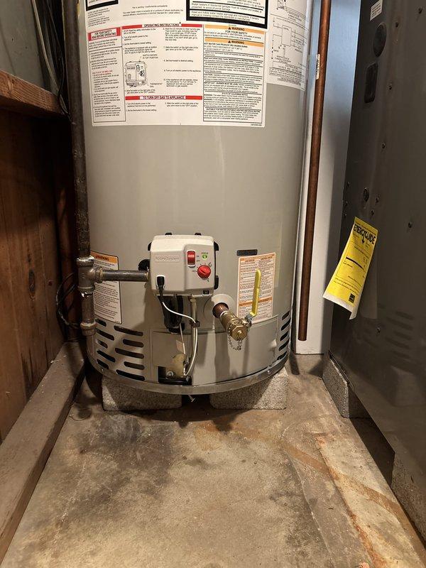 Responded to same-day service call for no hot water condition. Upon arrival, inspected existing water heater installation in basement utility area. Unit displayed signs of age and potential failure, with visible moisture staining on concrete floor beneath equipment indicating previous leakage or condensation issues. Water heater exhibited typical wear patterns consistent with end-of-service-life conditions. Basement environment showed evidence of moisture infiltration on concrete block walls, which can accelerate deterioration of mechanical equipment. Assessed system performance, evaluated control components, and reviewed manufacturer specifications on existing unit labels. Presented customer with repair options and recommended replacement solution to restore hot water service and prevent future emergency situations. Customer approved proposed water heater replacement to resolve no hot water issue and ensure reliable domestic hot water supply.