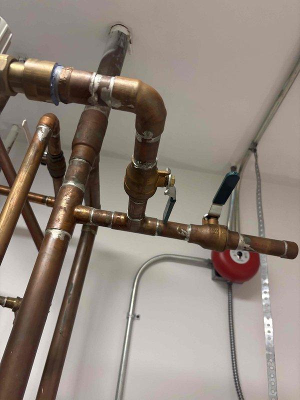 Responded to service call for significant loss of hot water throughout the home. Upon arrival, confirmed hot water was present at the tank and valve but only lukewarm or unavailable at multiple fixtures including shower. Inspected the indirect-fired water heating system and complex copper piping network. Diagnosed faulty thermostatic mixing valve assembly causing inadequate hot water distribution to fixtures. The mixing valve was failing to properly blend hot and cold water, resulting in insufficient hot water delivery despite proper tank operation. Adjusted and tested the mixing valve control to restore proper temperature balance. Verified hot water temperature and flow at all affected fixtures including shower. System returned to normal operation with adequate hot water supply throughout the home.