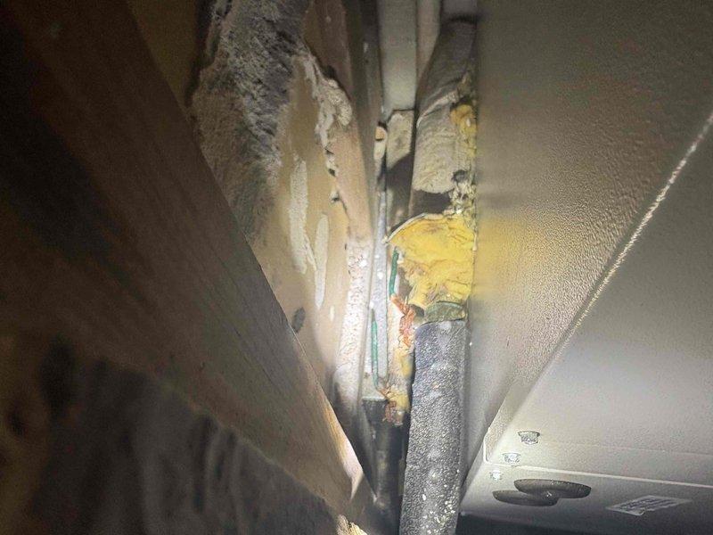 Responded to early morning service call and conducted inspection of HVAC system ductwork and return air components. Upon examination, identified deteriorated and damaged insulation on ductwork in ceiling cavity, with visible staining, compression, and previous repair attempts using spray foam insulation. Documented existing conditions showing compromised insulation integrity and irregular foam application around piping. Presented findings and sold repair services to address the insulation deficiencies and restore proper system efficiency.