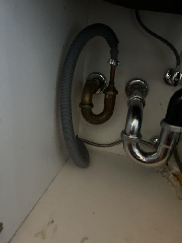 Responded to a water leak locate service call and performed a thorough inspection of the under-sink plumbing system. Upon examination, identified multiple areas of concern including an aging brass P-trap assembly with corroded connections, oxidized copper piping showing significant patina buildup, and deteriorating flexible drainage hoses. Documented the condition of all plumbing fixtures, noting the mixed-age components with both older brass and newer chrome assemblies present. Inspected all trap connections, tailpiece fittings, and wall-mounted drain pipes for signs of active leaking or moisture intrusion. Photographed the existing plumbing configuration to provide visual documentation of component conditions and potential failure points requiring future attention.